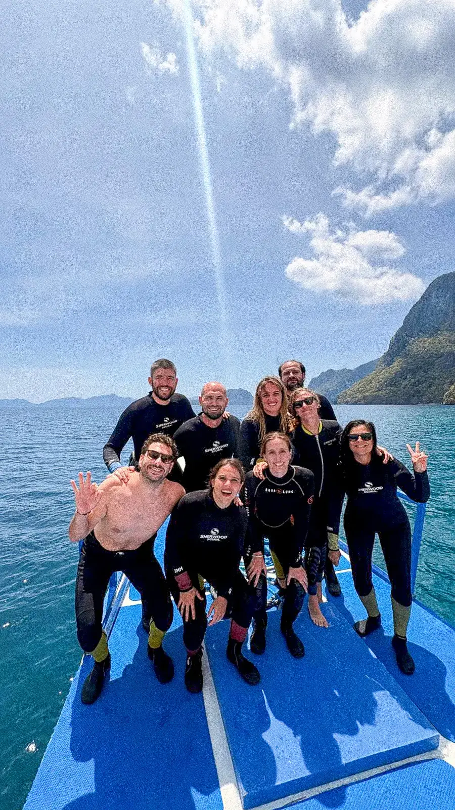 Un grupo con trajes de neopreno posando en la cubierta de un barco